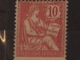 un vieux timbre sur lequel figure l'image d'une femme assise