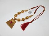 un collier plaqué or orné d'un pompon rouge, un collier plaqué or orné d'un pompon rouge et un collier plaqué or orné d'un pompon rouge