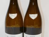 deux bouteilles de vin posées sur une table l'une à côté de l'autre