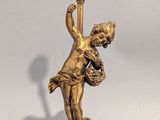 une lampe sur laquelle est représentée la statue d'un garçon tenant un panier