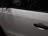 a small white car parked in a garage with its door open