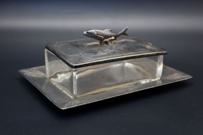 une boîte en verre sur laquelle est représenté un oiseau, posée sur une assiette
