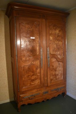 a large wooden armoire in the corner of a room