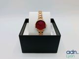 a close up of a watch in a box on a white surface