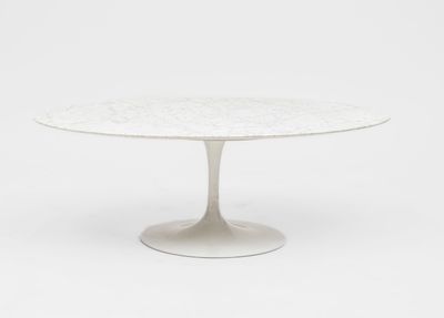 une table en marbre blanc avec un piètement circulaire et un socle blanc