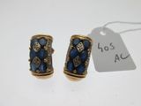 une paire de boucles d'oreilles ornées de pierres bleues et de diamants sur fond blanc