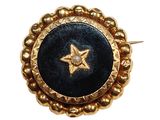 une image représentant une broche dorée et noire ornée d'une étoile