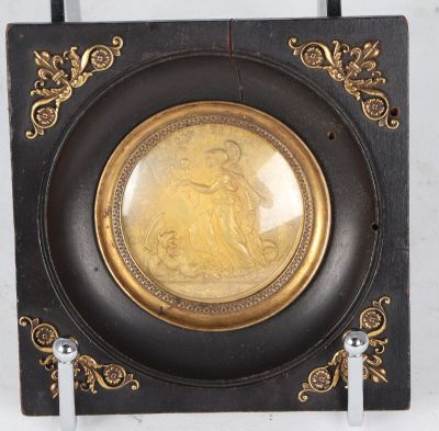 a black and gold plate with a picture of a woman on it