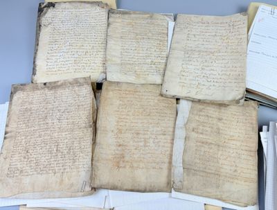 several old manuscripts are stacked on top of each other on a table