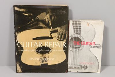 un livre sur la réparation des guitares et un manuel d'instructions posés l'un à côté de l'autre