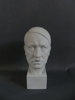 a white sculpture of a man ' s face on a black background