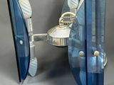 a blue glass table with a mirror and a silver plate