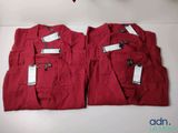 two pairs of red pants with tags on them sitting on a table