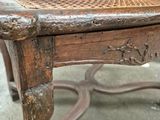 an old wooden chair with a cane back and a seat made of wood