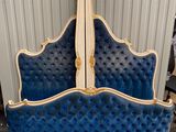 an image of a blue and white bed with gold trim