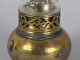 a small gold vase with a glass top on a table
