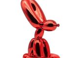 the red balloon dog sculpture is sitting on top of a table