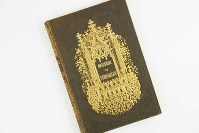 un vieux livre à la couverture dorée posée sur un fond blanc