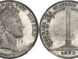 a close up of a silver coin with a statue on it