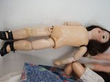 a doll that is laying on a bed next to another doll