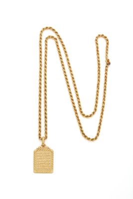 gros plan d'un collier en or avec une chaîne sur fond blanc