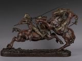 statue of a man on a horse holding a spear and riding a horse with another man on a horse behind him