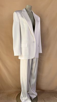 a white suit on a mannequin stand against a beige backdrop