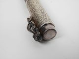 a silver pipe with a chain around it on a white surface