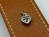 an apple charm on a brown leather strap with a white stitching