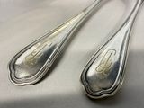 pair of silverware spoons on a table with a white background