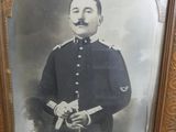 an old picture of a man in a uniform holding a rifle