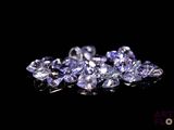 un gros plan sur un bouquet de diamants violets posés sur une surface noire