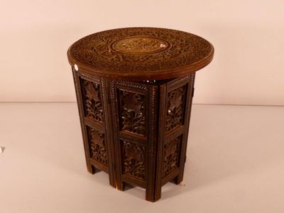 a small wooden table with intricate carvings on it