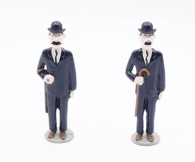 two figurines of a man in a suit and hat