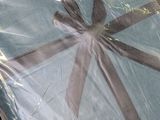 a blue blanket wrapped in plastic with a black ribbon