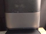 une enceinte noire posée sur une table en bois