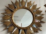 un miroir doré en forme d'étoile accroché au mur