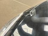 a black car parked in a parking lot next to a building