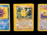Trois cartes Pokémon sont représentées en ligne sur un fond noir