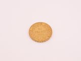 une pièce d'or sur une surface blanche avec un fond blanc