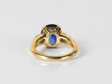 a close up of a gold ring with a blue stone