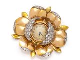 an image of a gold and diamond flower brooch with a clock
