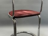 une image représentant une chaise avec une assise rouge et un piètement chromé