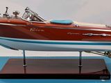 a model of a speed boat on display on a blue surface