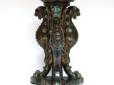 a bronze elephant on a pedestal on a white background