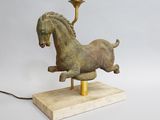 une image représentant une statue de cheval posée sur un socle en bois