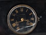 a black clock with roman numerals on it