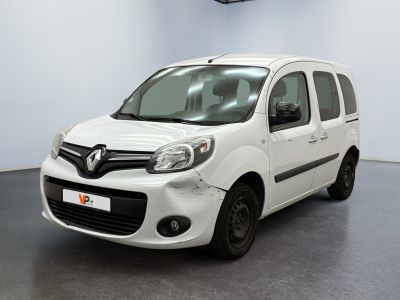 La camionnette blanche est garée dans une grande pièce au sol noir.