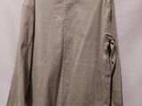 a beige jacket hanging on a hanger against a white wall
