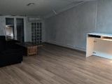 a black couch in a room with a skylight above it
